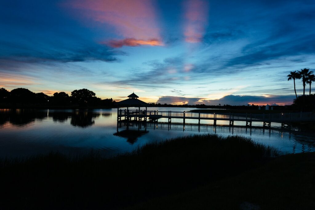 Dock and gazebo on calm water at dusk