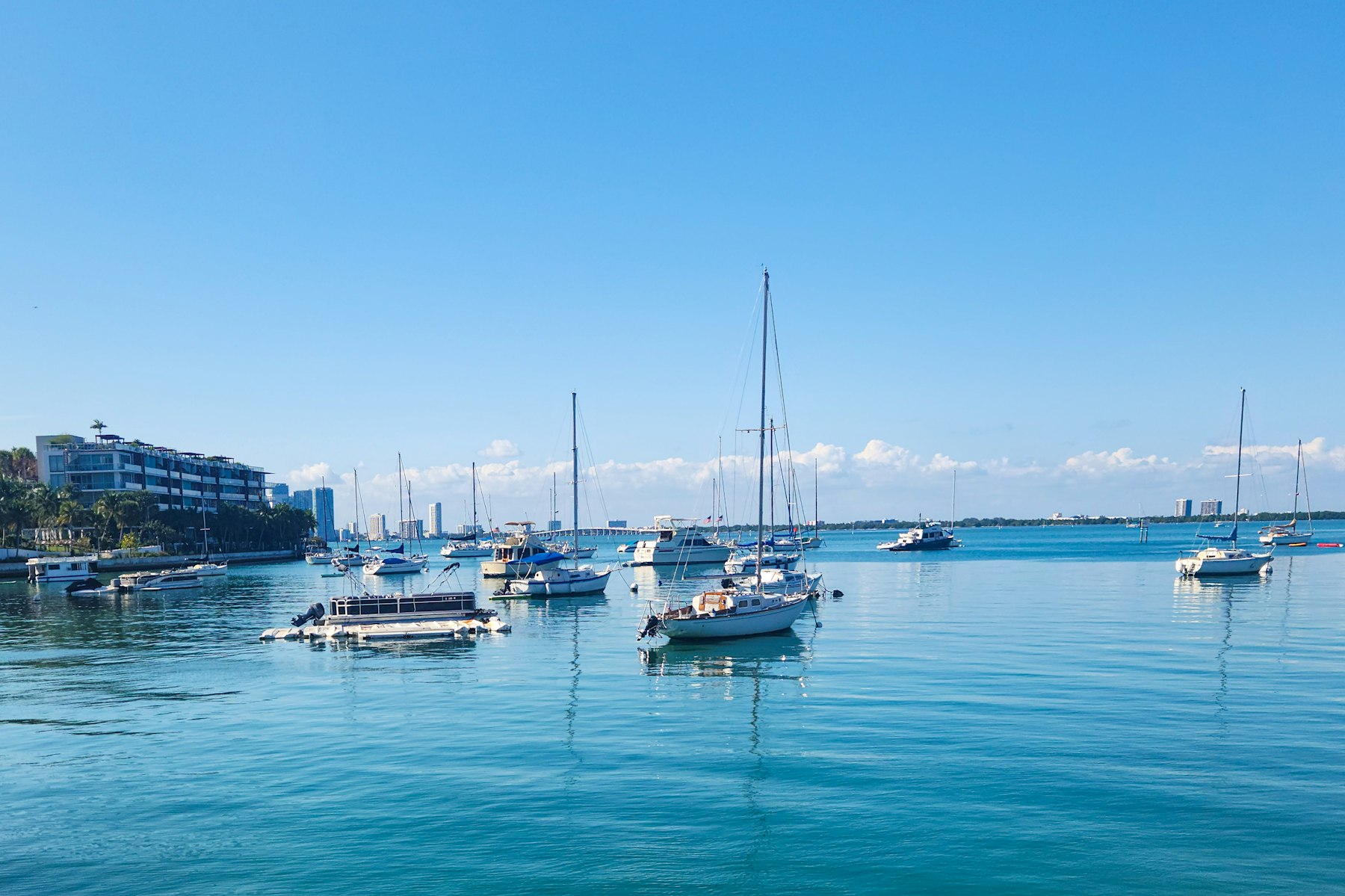 Sailboats anchored off the waterfront on a clear day
