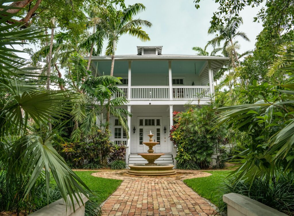 Old Florida two story home with a lush tropical yard
