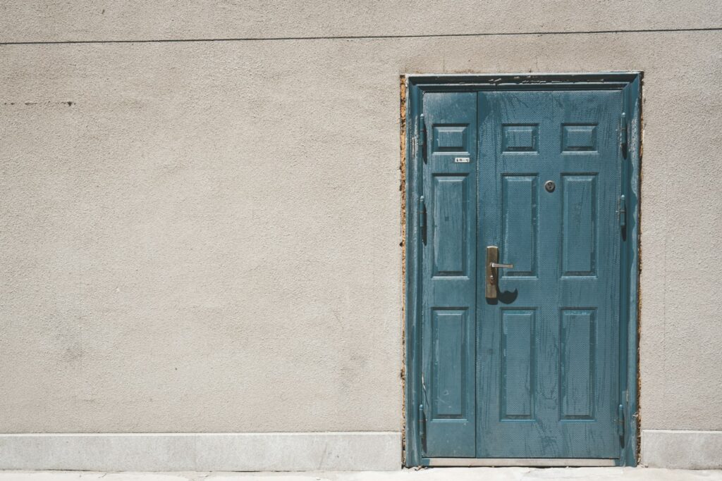 Teal door on a stucco wall