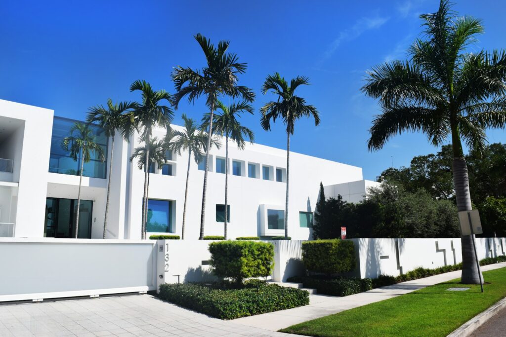 White home behind palms on a sunny street